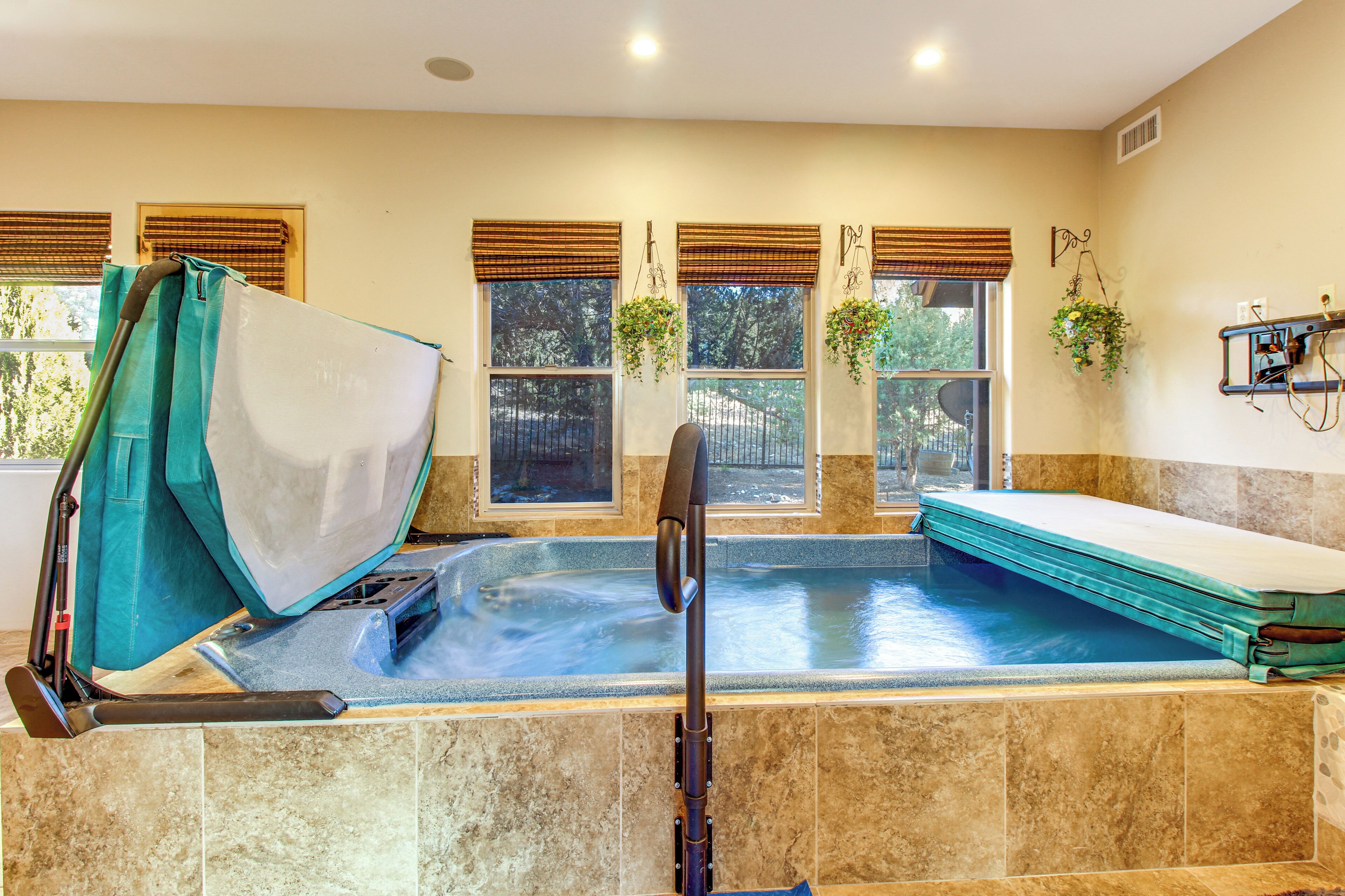 Un espace bien-être comprenant un jacuzzi, une table de massage et un fauteuil de massage.