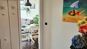 Uma sala de jantar com mesa, cadeiras e uma planta pendente.