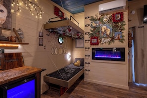 A cozy room with a bunk bed, a small desk, a fireplace, and wall decorations. - 63-OWL ALWAYS LOVE YOU (Sevierville)