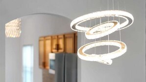 Eine moderne Küche mit einer Pendelleuchte und Holzschränken.