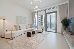 Una sala de estar moderna con sofá, mesa de centro y mueble para televisión.