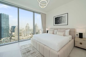 Un dormitorio moderno con una cama grande, una mesita de noche, una lámpara de pared y vistas a la ciudad.
