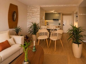 A modern living room with a sofa, chairs, a coffee table, and potted plants. - Luxury Apartment in Cali's Zona Rosa—Terrazas de Granada (Cali)