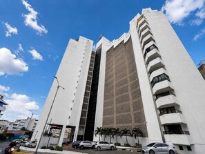 A tall, modern building with a unique facade, featuring a large vertical window and a patterned section. - Luxury Apartment in Cali's Zona Rosa—Terrazas de Granada (Cali)