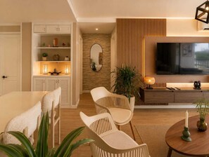 A modern living room with a TV, seating area, and a wooden accent wall. - Luxury Apartment in Cali's Zona Rosa—Terrazas de Granada (Cali)