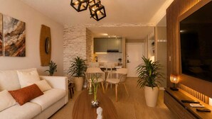 A modern living room with a sofa, coffee table, and dining area. - Luxury Apartment in Cali's Zona Rosa—Terrazas de Granada (Cali)