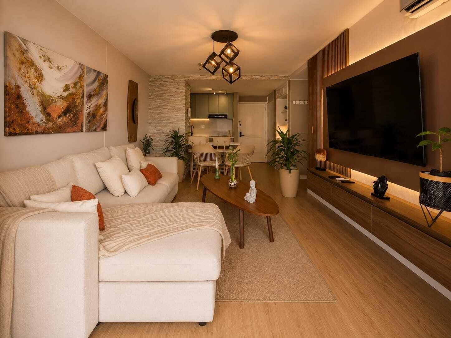 A modern living room with a sofa, coffee table, and a flat-screen TV.