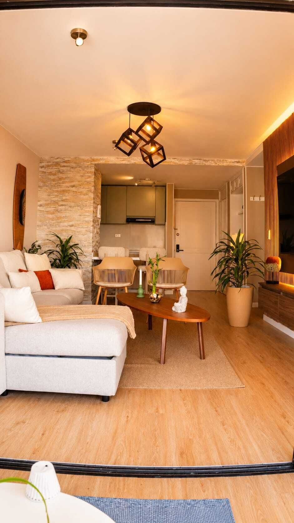 Ein modernes Wohnzimmer mit einer Couch, einem Esstisch und einer Küche im Hintergrund.