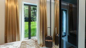 Une chambre à coucher avec un lit, une porte-fenêtre coulissante donnant sur un balcon et deux valises.