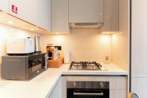 Deluxe Apartment | Private kitchen | Full-sized fridge, microwave, oven, stovetop - Luxury 1BR High-Floor Retreat (Dubai)