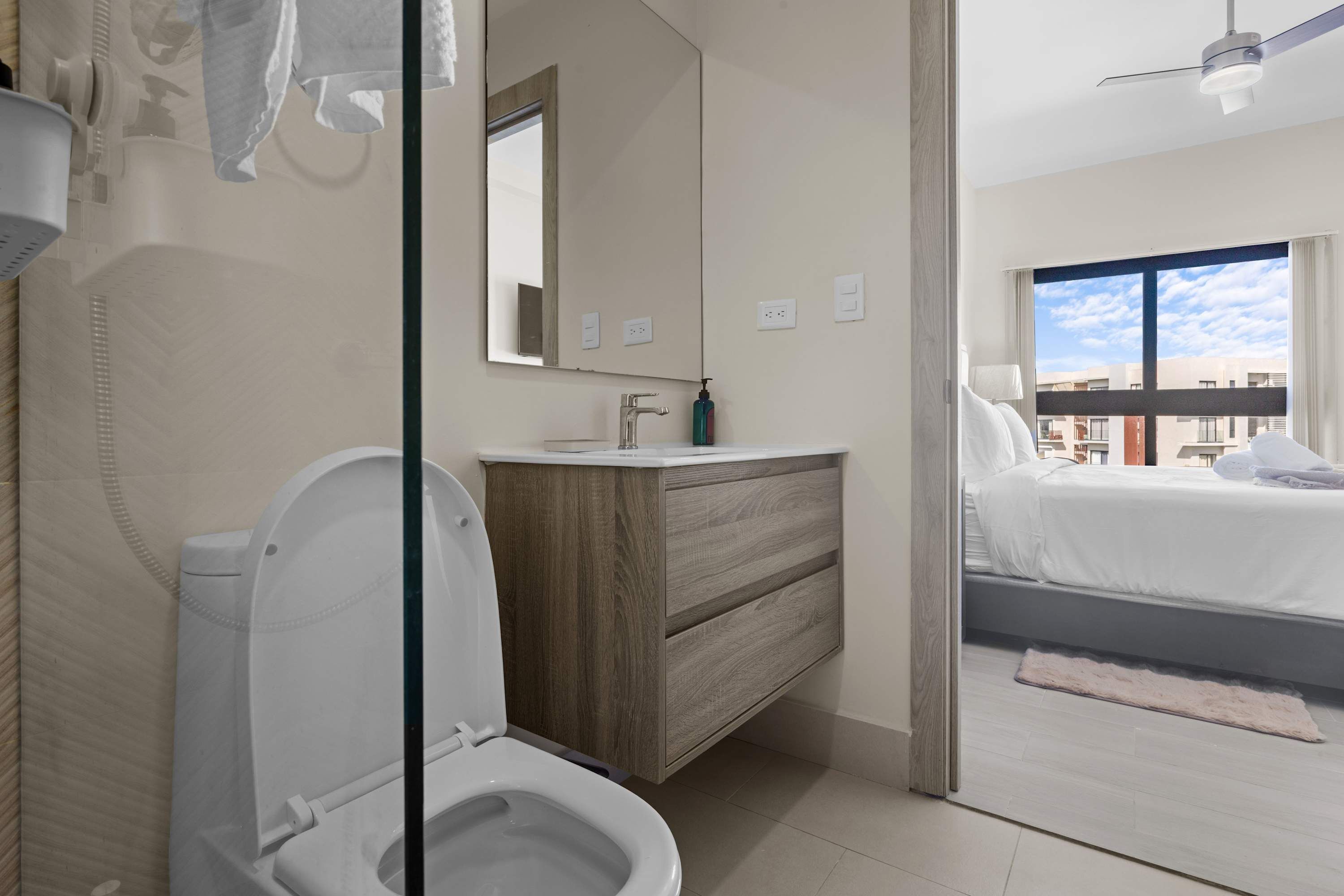 A modern bathroom with a toilet, sink, and vanity.
