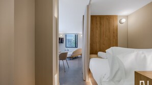 Une chambre d’hôtel moderne, équipée d’un lit, d’un bureau et d’une chaise.