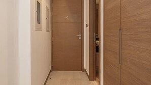 A narrow hallway with a wooden door and a wardrobe. - Elegant High Floor 2BR Furnished Urban Oasis (Dubai)