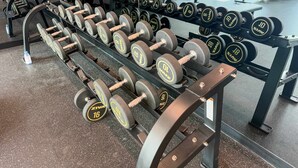 A gym with weightlifting equipment, including dumbbells and barbells. - Elegant High Floor 2BR Furnished Urban Oasis (Dubai)
