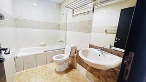 Bañera con ducha, toallas, papel higiénico