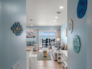 Una sala de estar amplia con un gran ventanal, un comedor y una cocina.