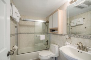 Un bany amb dutxa de vidre, vàter i rentapins.