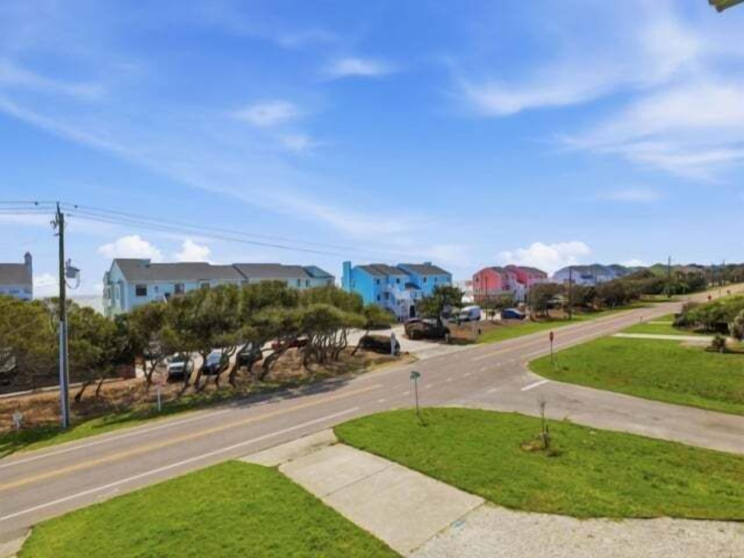 A residential street with houses, a sidewalk, and a road.