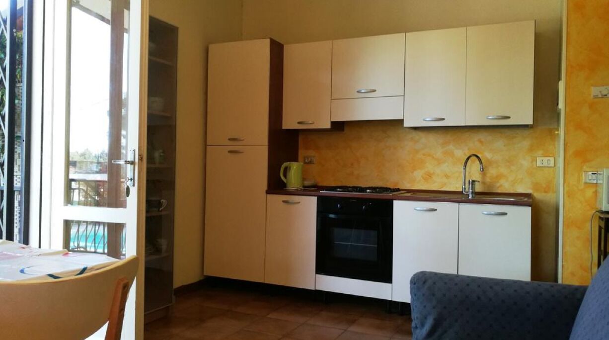A compact kitchen with a stove, sink, and cabinets.