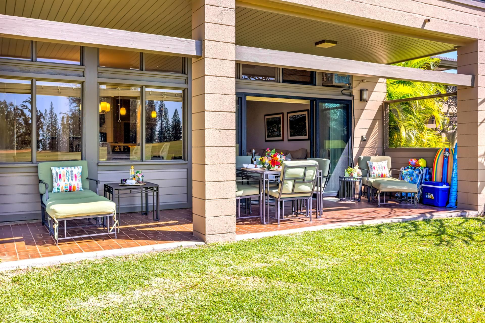 Un patio couvert avec coin salon extérieur, une table à manger et une vue sur le paysage environnant.
