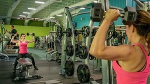 Een sportschool met diverse fitnessapparaten, waaronder gewichten en krachtapparaten.