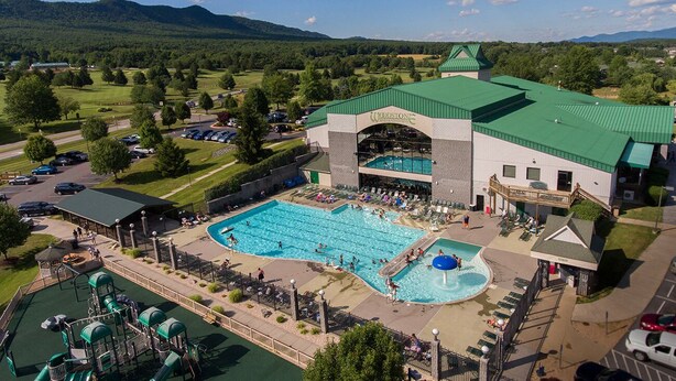 Een hotel met een groot zwembad, een waterpark en uitzicht op het omliggende landschap.