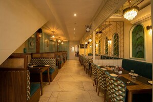 Un restaurante con una barra larga, mesas con cabinas y sillas estampadas.