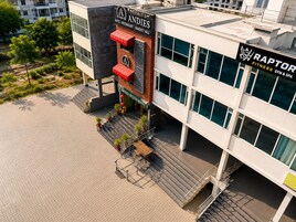 Un hotel con un letrero llamativo para 'Andies Restaurant' y un gimnasio y spa llamado 'Raptor Fitness Gym & Spa' en la planta baja.