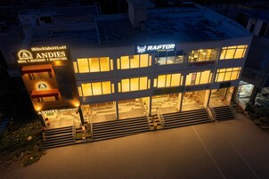 Un hotel con un restaurante llamado 'Andies' en la planta baja, un cartel que dice 'Raptor' en el nivel superior y una escalera que conduce a la entrada.