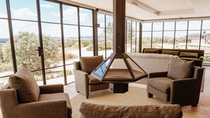 A spacious living room with large windows offering a view of the outdoors. - FINCA LOS COLLADOS DE SAN MIGUEL (Villamanrique)