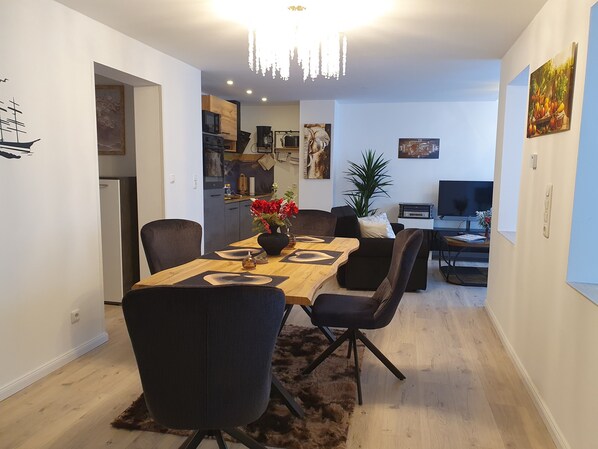 Un espace de vie moderne comprenant un coin repas, une cuisine et un espace de détente.