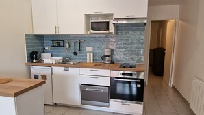 A compact kitchen with white cabinets, a microwave, a coffee maker, and a dishwasher. - Banyuls-sur-Mer: Sea View Apartment, Terrace, Private Parking, 4 People (Banyuls-sur-Mer)