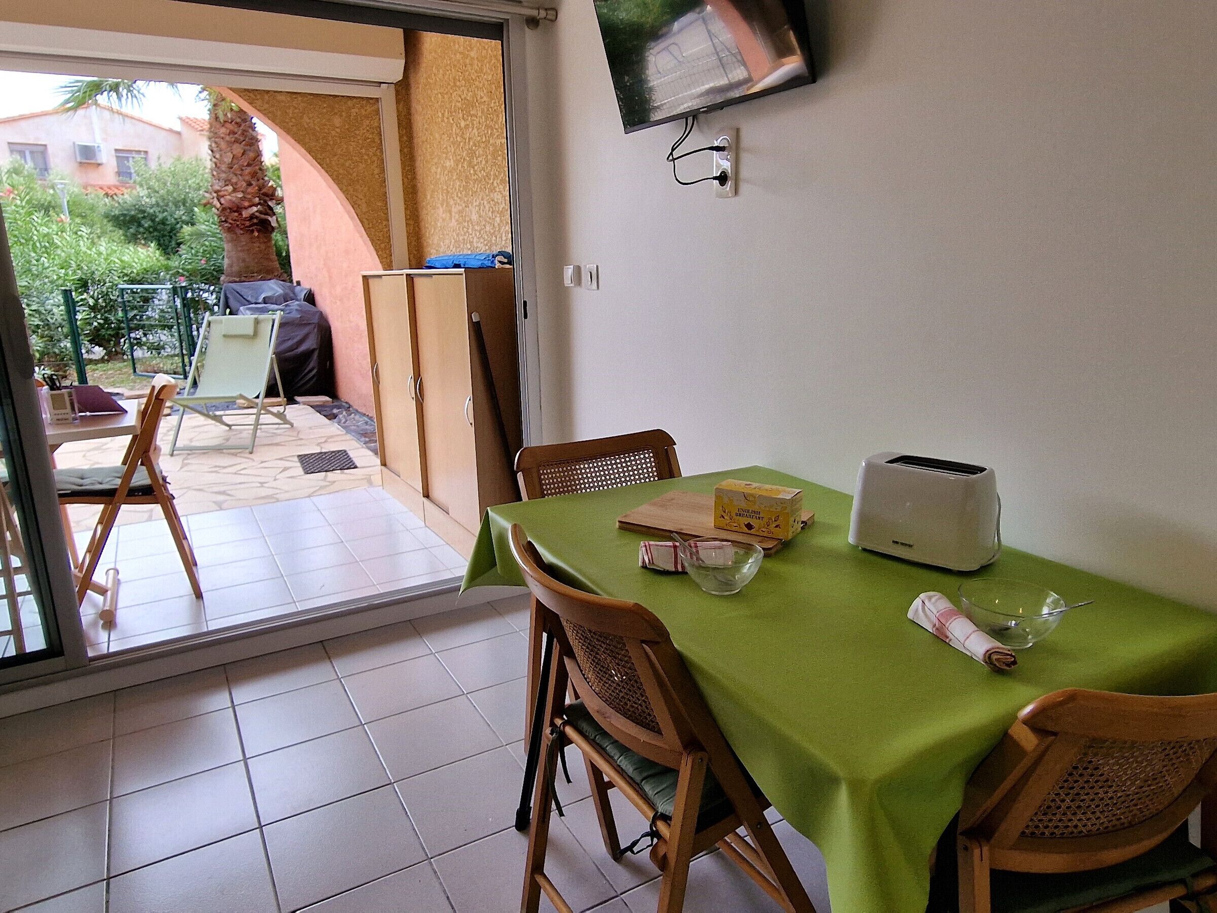 A dining area with a table set for two, a toaster, and a bowl.