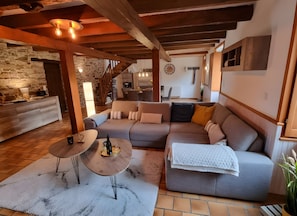 A cozy living room with a sofa, a coffee table, and a fireplace. - Gîte La Maison Neuve – Perfect for the Whole Family (Béganne)
