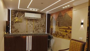 A reception area with a marble counter, air conditioning unit, and a mural of pyramids on the wall. - ش ابو الهول السياحى (giza)