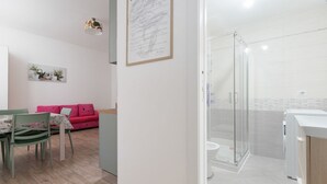 Une salle de bain moderne avec une douche à parois de verre, des toilettes et un lavabo.