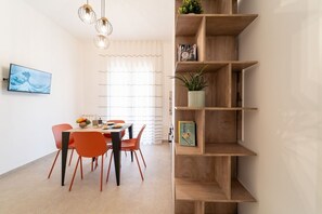 Un comedor con mesa, sillas y una estantería.