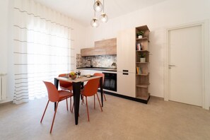 Eine moderne Küche mit Esstisch, Stühlen und einem eingebauten Backofen.