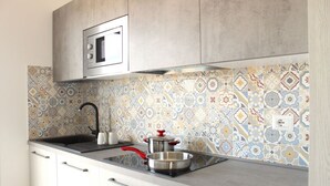 A kitchen with a microwave, stove, and sink. - Spacious 40 square meter apartment with independent access via magnetic card. The accommodation includes a fully equipped kitchenette, a living room with a comfortable sofa bed for two, a bedroom with a double bed, and a private bathroom with a shower an (Stintino)