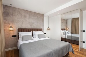 A modern bedroom with a large bed, a mirror, and pendant lighting. - Villa Oliva Zadarvillas (Primosten)