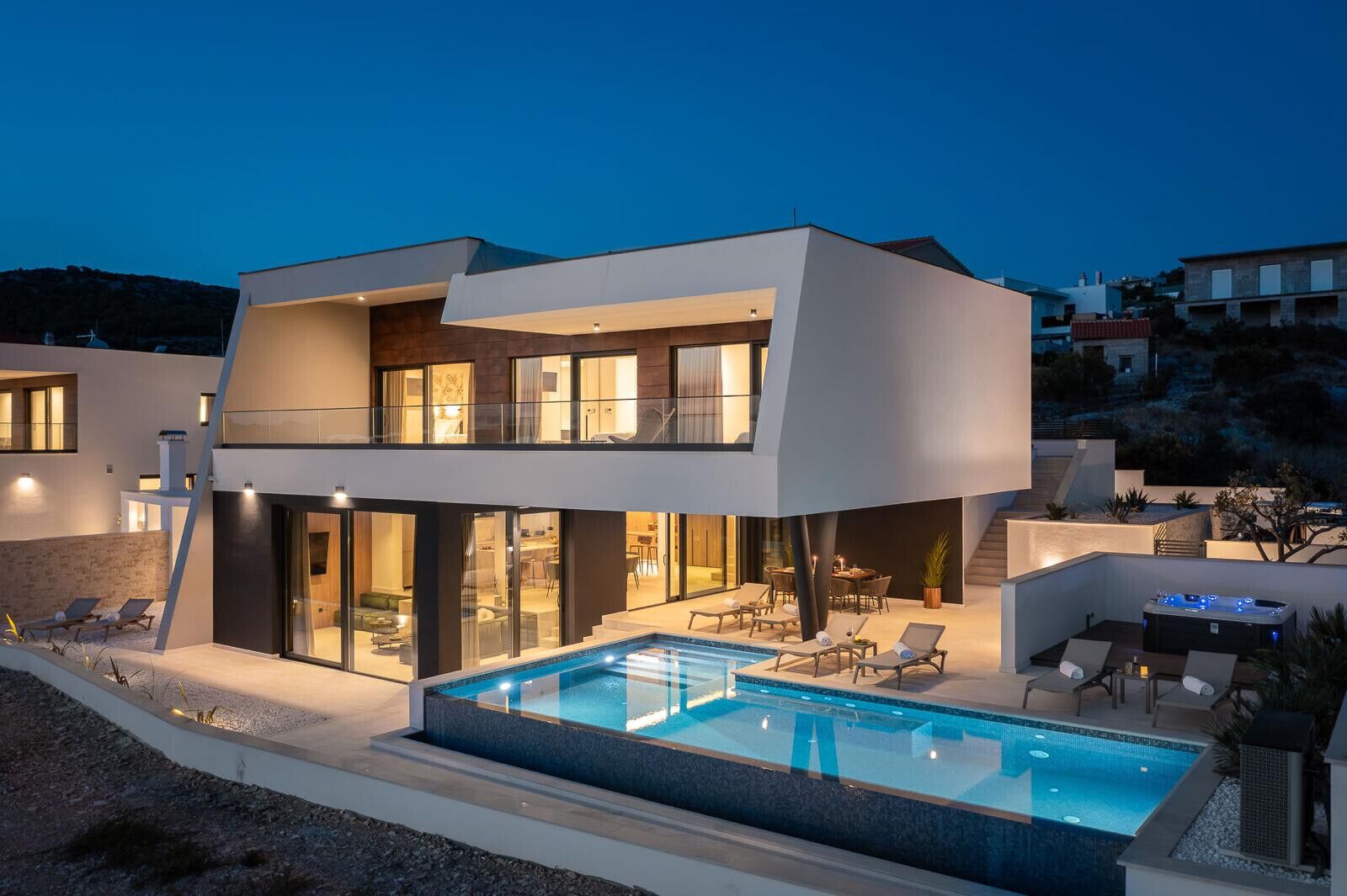 Een modern herenhuis met zwembad, terras en uitzicht op het omliggende landschap.