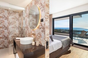 A modern bathroom with a large mirror and a bathtub, and a bedroom with a large window overlooking a scenic view. - Villa Oliva Zadarvillas (Primosten)