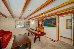 Ein Zimmer mit einem Kicker, einem roten Sofa und einem Gemälde an der Wand.