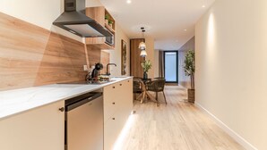 Una cocina moderna con estufa integrada, armarios de madera y una zona de comedor con mesa y sillas.