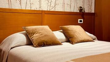 A neatly made bed with two pillows and a striped blanket.