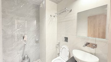 Habitación triple Deluxe, vista a la ciudad | Baño | Regadera, toallas, jabón, shampoo