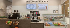 A coffee shop with a menu board, a coffee machine, and a display case with snacks. - Club Wyndham Grand Desert Formula 1 Las Vegas Grand Prix Week (Las Vegas)