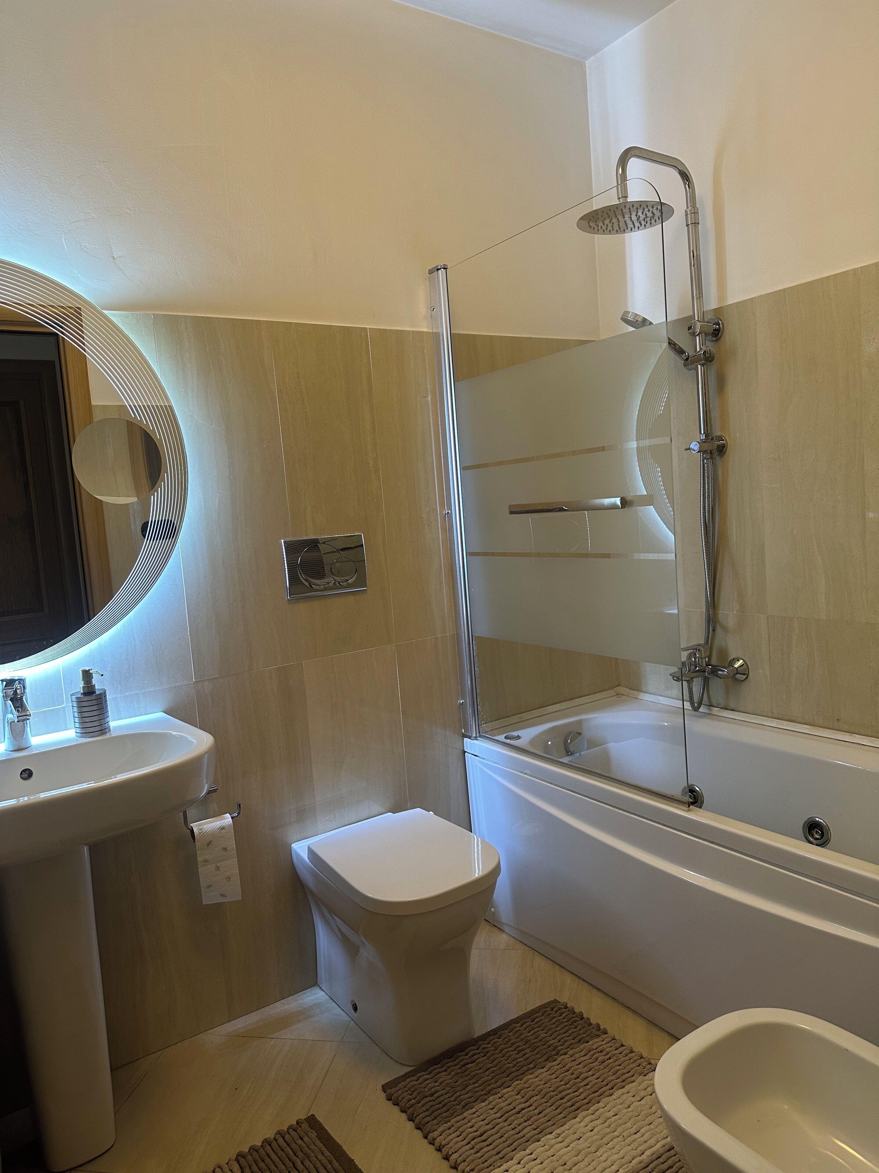 A bathroom with a toilet, sink, bathtub, and shower.