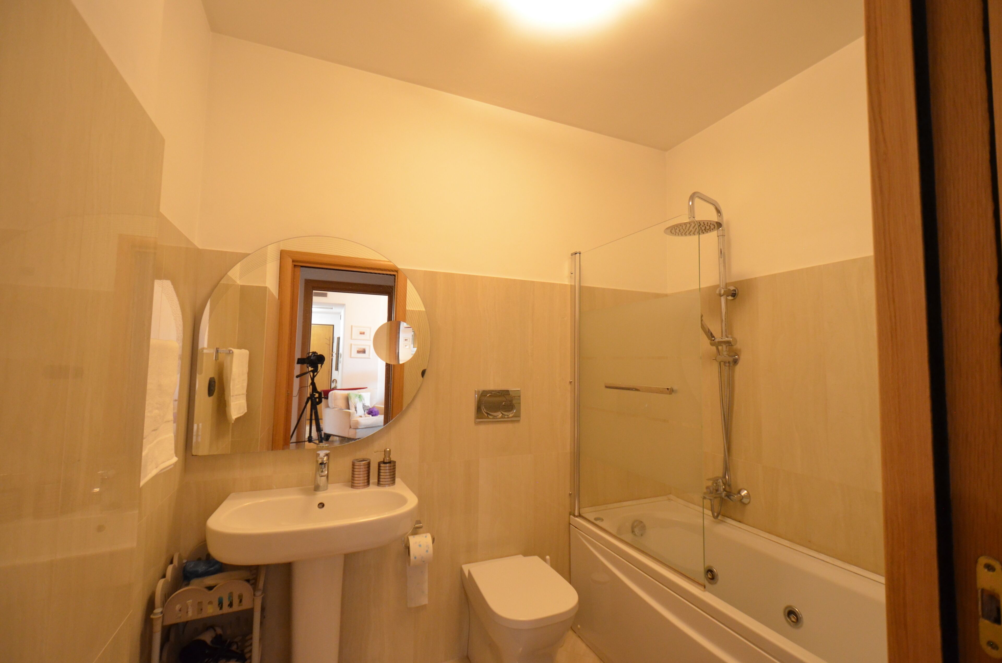 A bathroom with a sink, toilet, and glass-enclosed shower.