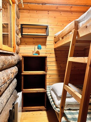 A wooden cabin room with a bunk bed, a desk with a lamp, and a window. - Pikkukelo Ruka - a cozy accommodation in a great location, skibus and free wifi. (Kuusamo)